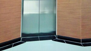 Un ascenseur doté d’un panneau de commande et d’un téléphone fixé au mur.