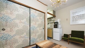 Ein Zimmer mit Holztisch, grünem Sofa und einer Wand mit einem Motivationsspruch.