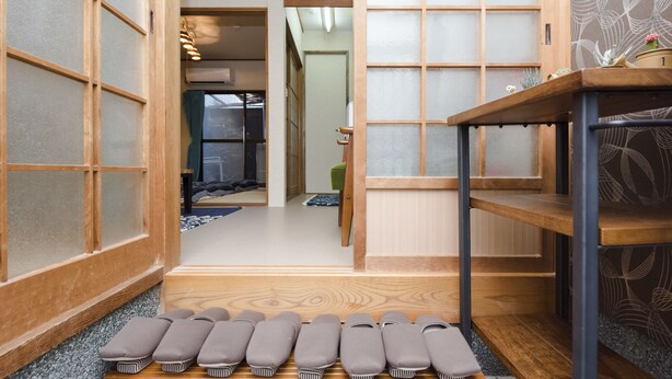 Ein traditioneller japanischer Raum mit Tatami-Böden, Schiebetüren und einem Holzboden mit Kissen.