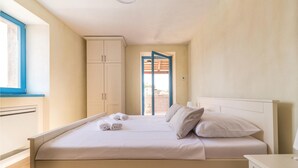 A bedroom with a bed, a wardrobe, a window, and a door leading to an outdoor area. - Beautiful home in Bokordici (Bokordici)