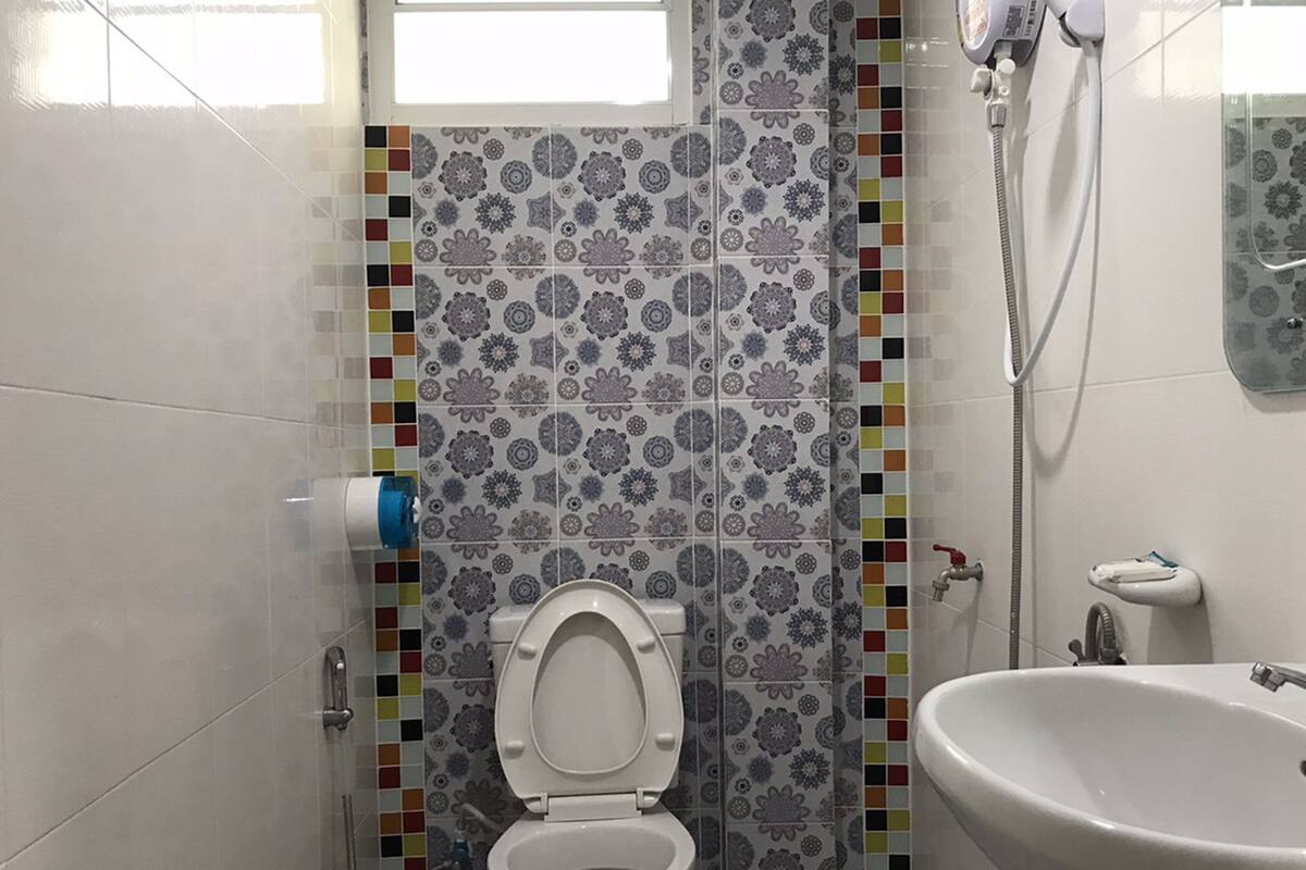 Une salle de bain avec des toilettes, une douche et un lavabo.