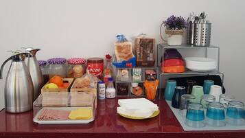 Una mesa de buffet con diferentes alimentos, bebidas y utensilios.