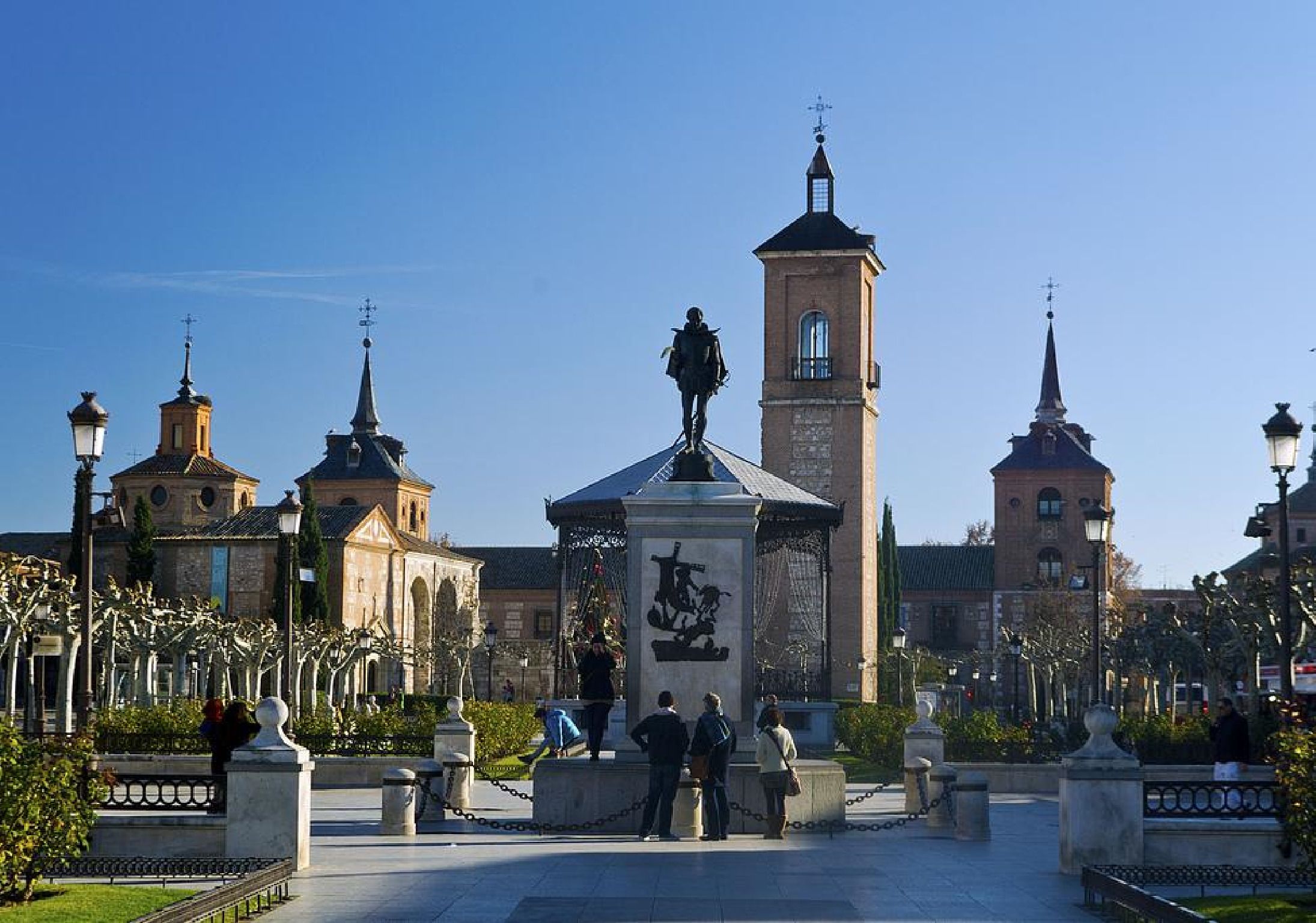 Una plaza con un monumento central, rodeada de edificios con cúpulas y torres.