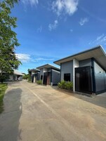 Un moderno conjunto residencial con un camino pavimentado que conduce a varias casas.
