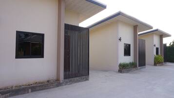 A modern building with a flat roof, large windows, and a gated entrance.