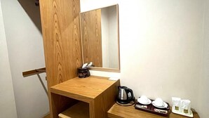 Un baño de madera pequeño y acogedor con lavamanos, espejo y repisas con artículos de tocador.