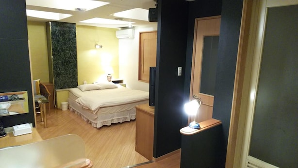 A hotel room with a bed, bedside table, lamp, and a television. - HOTEL ESSOR - Adult Only (Nara)