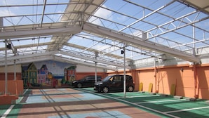 An indoor parking area with a colorful floor design, a mural on the wall, and a car parked inside. - HOTEL ESSOR - Adult Only (Nara)