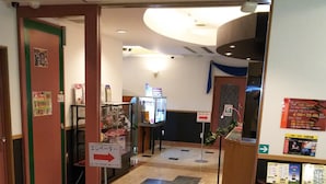 A hotel lobby with a reception desk, a glass display case, and directional signs. - HOTEL ESSOR - Adult Only (Nara)