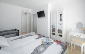 A bedroom with a bed, a TV, a wardrobe, a desk, and a mirror. - Lovely home in Marici with sauna (Marici)