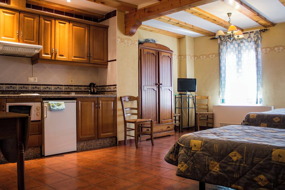 Una cocina con armarios de madera, un refrigerador y una mesa de comedor.