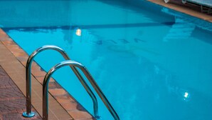 Una piscina con barandillas metálicas y cubierta de madera.
