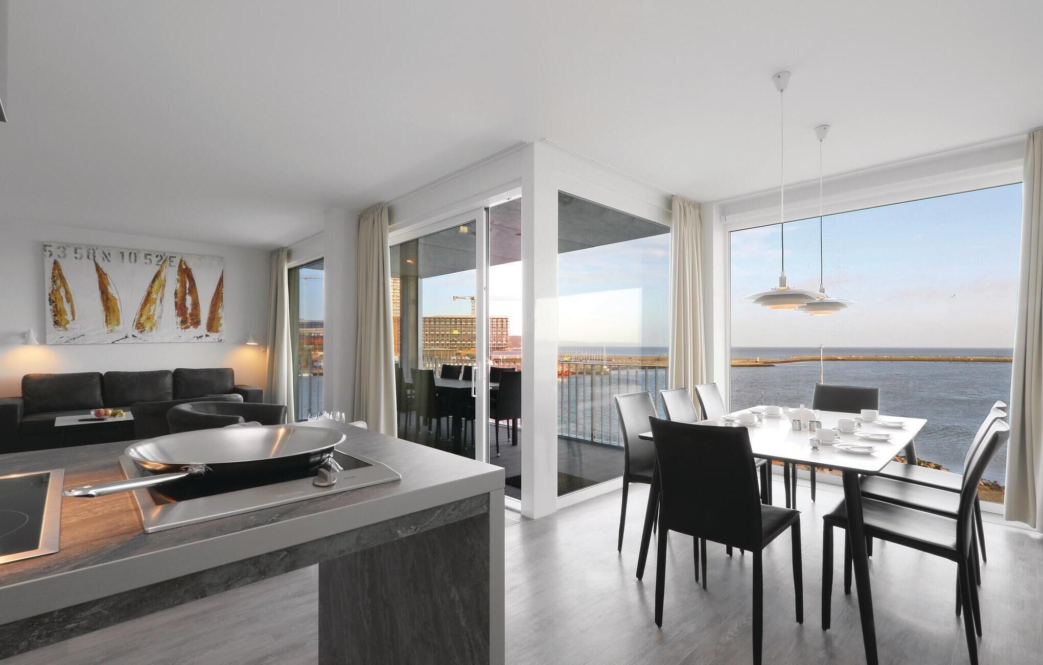 A modern kitchen with a dining area overlooking a waterfront.