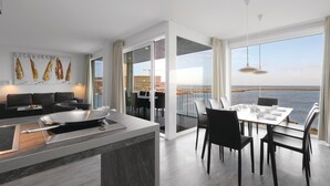 Een moderne keuken met een eethoek met uitzicht op het water.