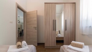 A bedroom with two beds, a wardrobe, and a mirror. - Awesome home in Vodnjan (Vodnjan)