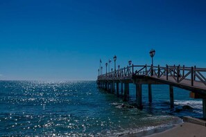 Un muelle que se adentra en el océano bajo un cielo despejado.