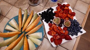Una bandeja de frutas con frutas cortadas y un plato decorativo.