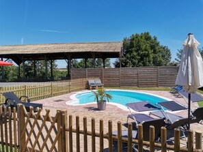Una piscina al aire libre, sombrillas, tumbonas