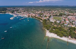 An aerial view of a coastal town with a marina, residential buildings, and a beach. - Amazing home in Fazana (Fazana)