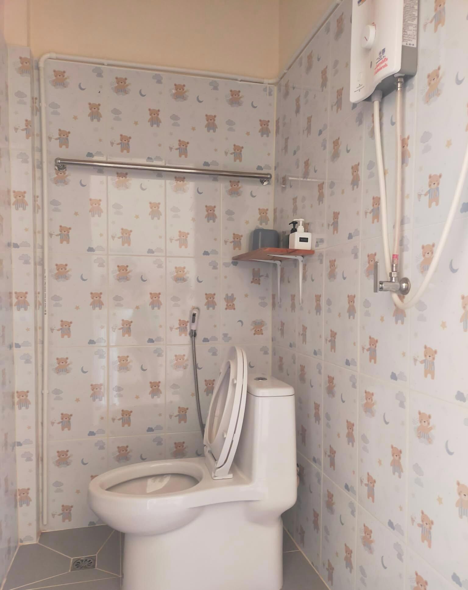 Un baño con inodoro, ducha y un estante con artículos de aseo.