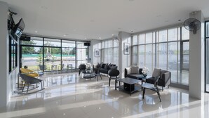 A spacious, modern lounge area with large windows, comfortable seating, and a clean, polished floor.