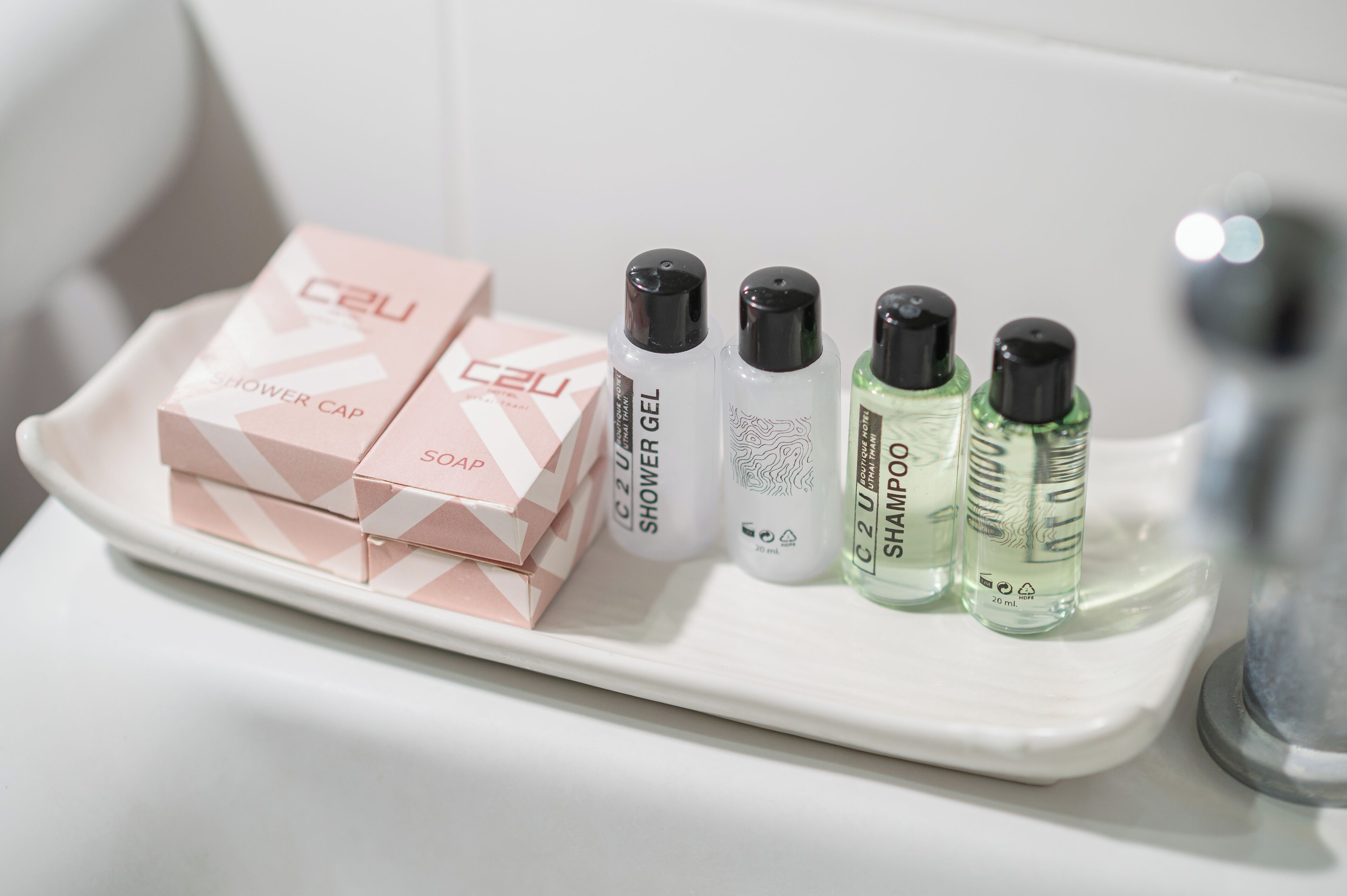 Un estante en el baño con gorro de ducha, jabón, gel de baño y botellas de champú.