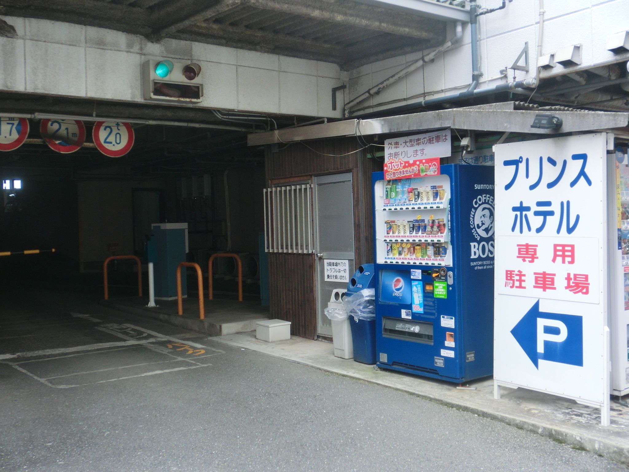 A parking area with a vending machine and a sign indicating a parking lot.