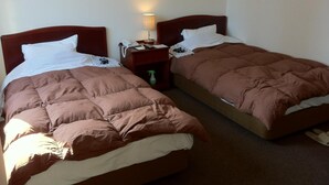 Two single beds with brown bedding, a nightstand with a lamp, and a telephone. - Prince Hotel Shimonoseki (Shimonoseki)