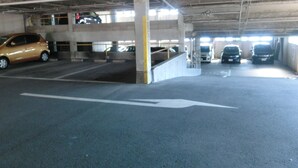 An underground parking garage with multiple levels, concrete pillars, and marked parking spaces. - Prince Hotel Shimonoseki (Shimonoseki)