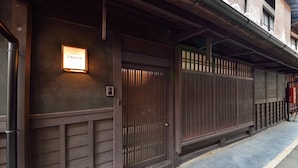 A traditional Japanese building with a wooden facade, a signboard, and a sliding door. - Takeya Kitano Honkan (Kyoto)
