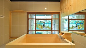 A modern bathroom with a wooden bathtub, large windows with stained glass, and a wooden ceiling. - Takeya Kitano Honkan (Kyoto)