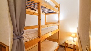 A bunk bed room with a small table and lamp. - Bright studio in Flaine center with balcony, sleeps 4 (Flaine)