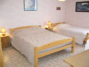 Une chambre avec un lit simple, une table de chevet avec une lampe et une petite table de chevet avec une lampe.