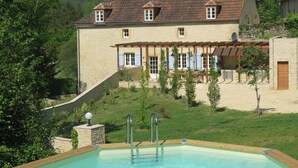 A house with a swimming pool, a covered outdoor area, and a hillside backdrop. - HOUSE OF CEDAR, BEAUTIFUL STONE HOUSE IN DORDOGNE. (Auriac-du-Périgord)