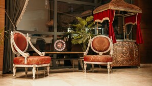 Two ornate chairs with red upholstery and a decorative cabinet with a canopy. - Grand Vaves Otel (Trabzon)