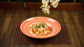 A plate of food on a wooden table with a placemat underneath.