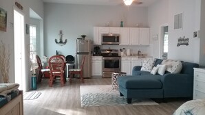 A compact living space with a kitchenette, a dining area, and a seating area with a sofa.