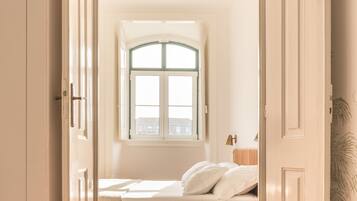 Una camera da letto con un letto, una finestra e una porta.