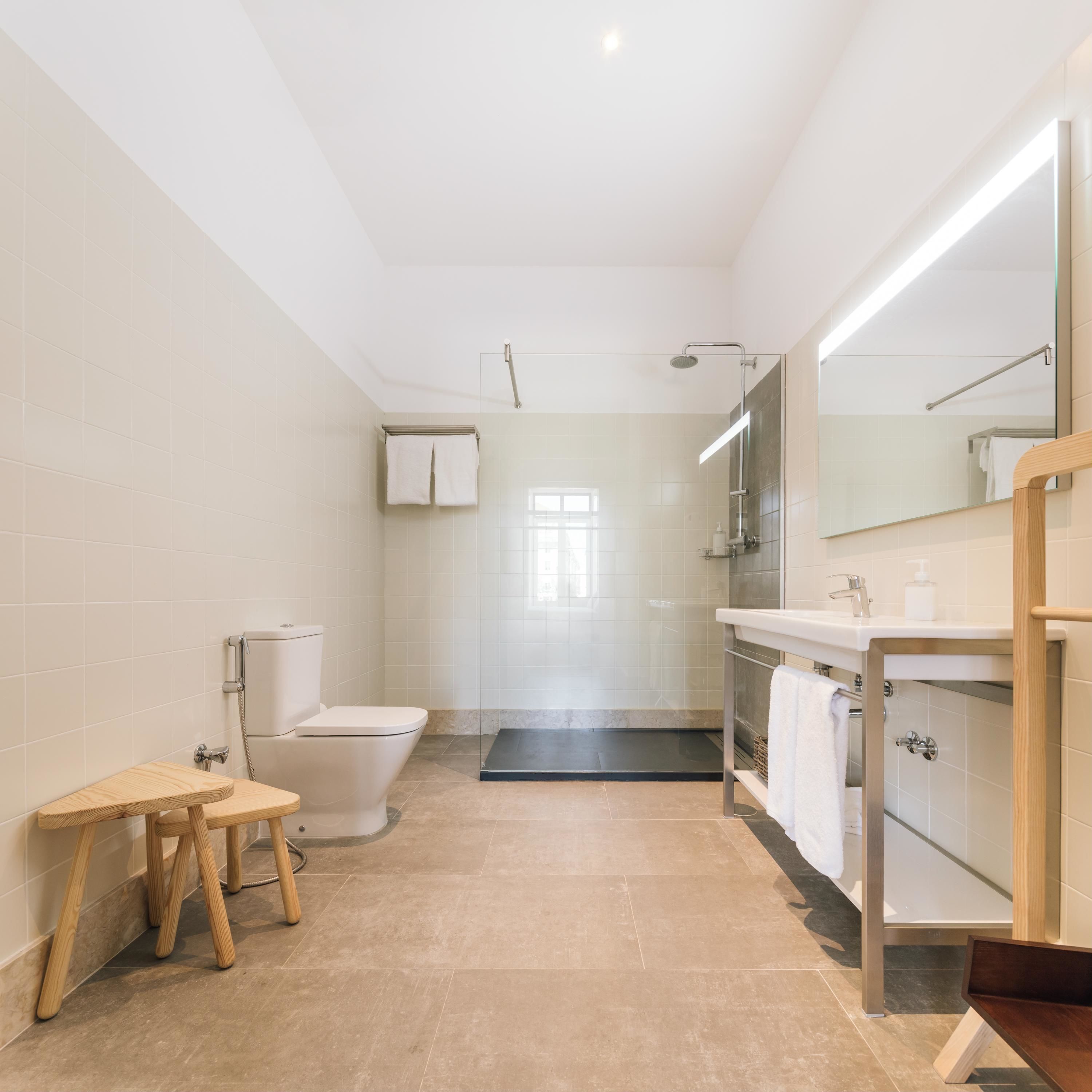 A modern bathroom with a toilet, shower, and sink.