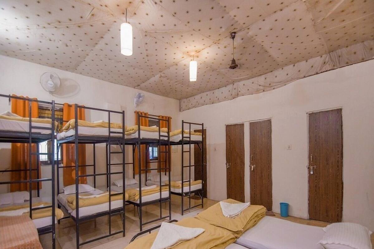 Un dormitorio con literas, una cama individual, puertas de madera y un techo decorado con un diseño de estrellas.