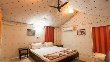 A room with a bed, a nightstand, a ceiling fan, and a wall-mounted air conditioner.