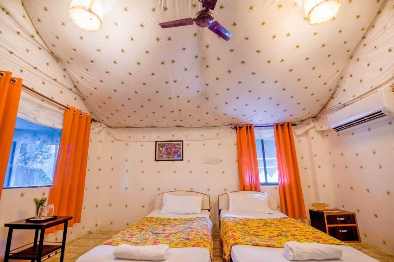 Ein Zimmer mit zwei Betten, einem Deckenventilator und einem fenster mit Vorhängen.