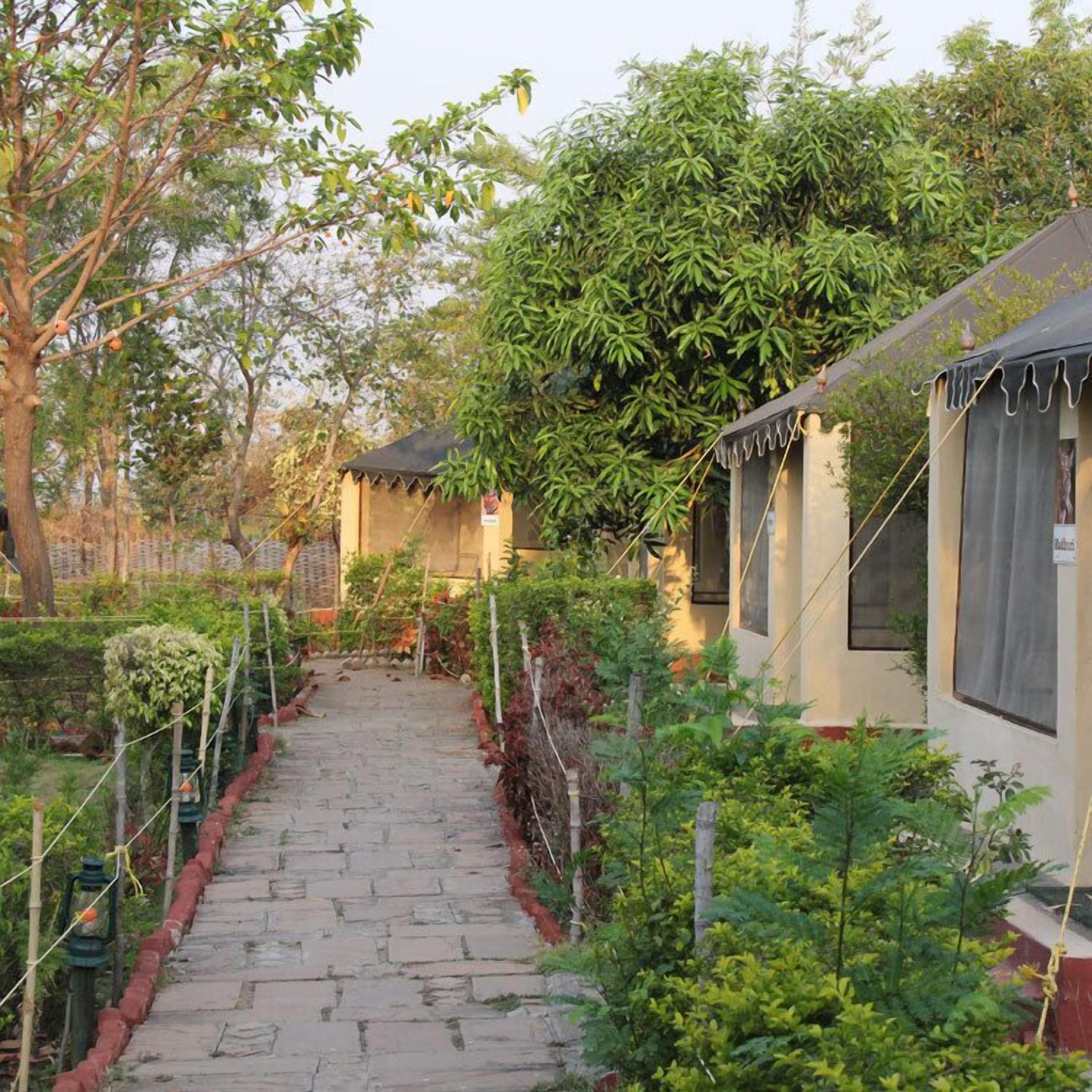 A pathway leading to a building with a tiled roof and a covered porch area.