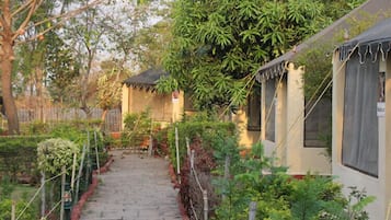 A pathway leading to a building with a tiled roof and a covered porch area.