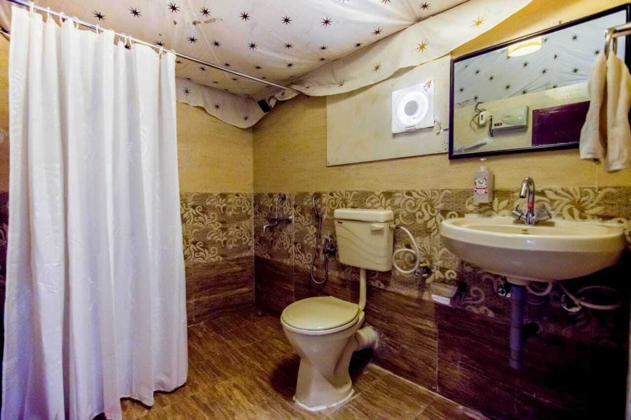 A bathroom with a toilet, sink, and shower curtain.