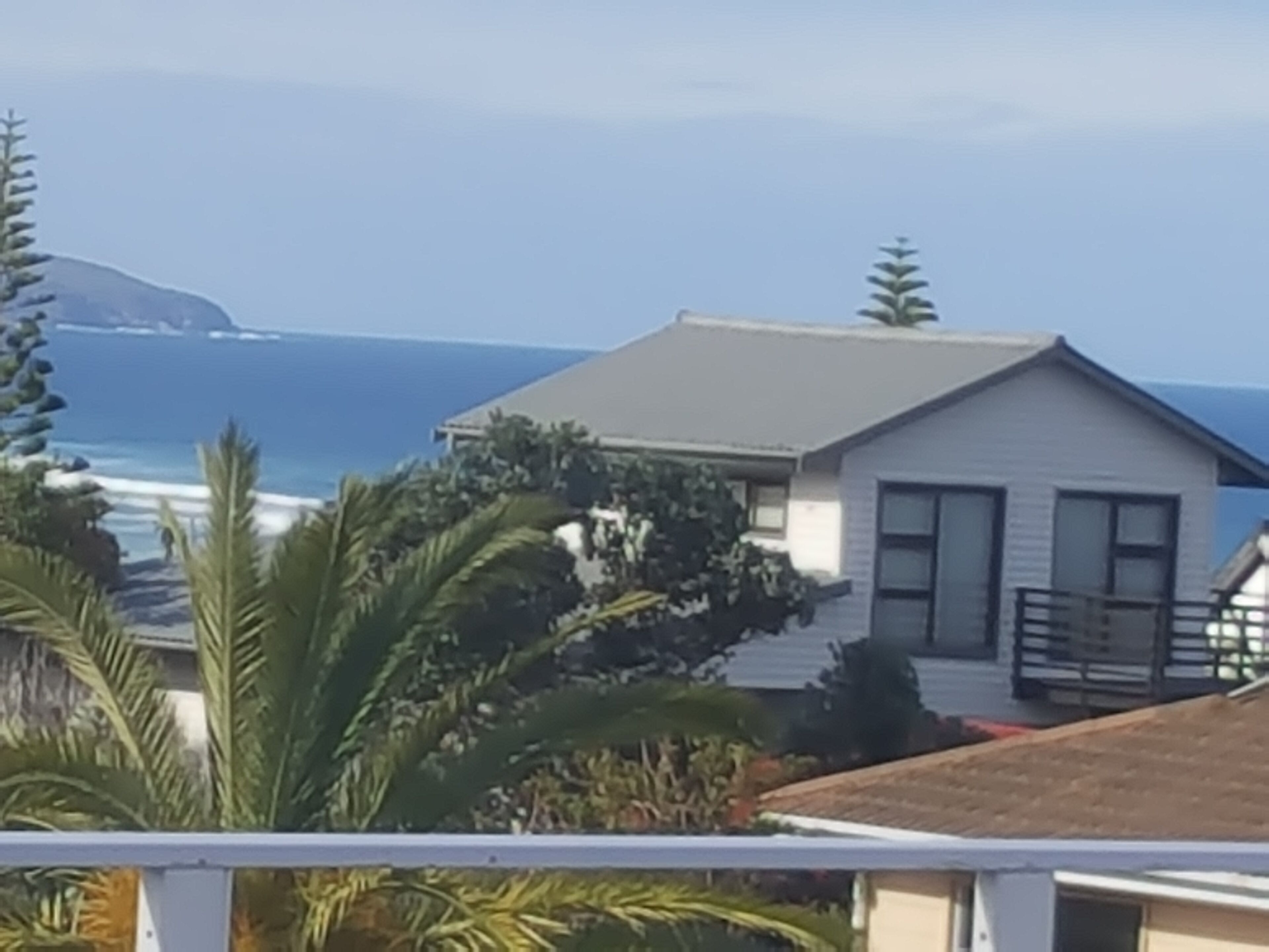 Een huis aan de kust met een balkon met uitzicht op de oceaan.