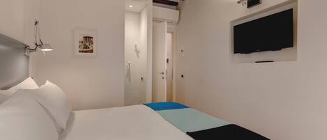 Ein Schlafzimmer mit einem Bett, einem an der Wand montierten Fernseher und einer Tür zu einem anderen Raum.