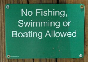 A green sign with white text stating "No Fishing, Swimming or Boating Allowed."