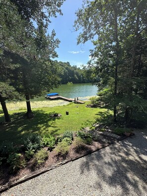 A lakeside campsite with a dock, grassy area, and trees. - Cabin/Vacation Home In the Woods on Private Lake Close to Louisville, Ky (Elizabeth)