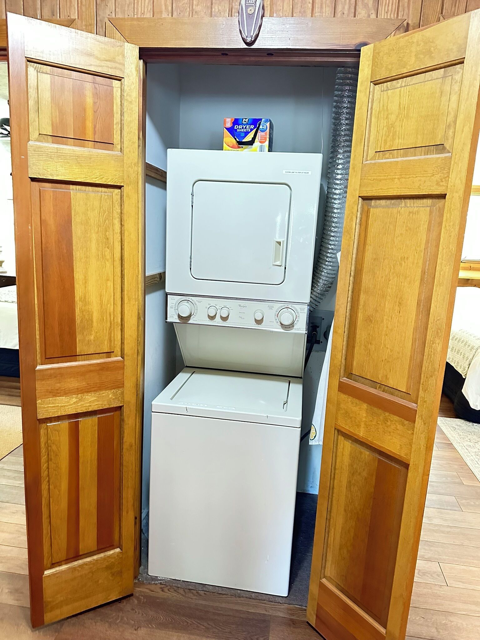Ein kleiner, weißer, zweitüriger Schrank mit einer Mikrowelle und einem kleinen Kühlschrank im Inneren.